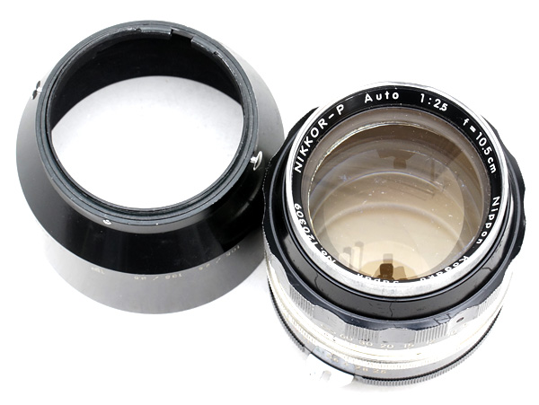 Note that the marking includes "f = 10.5cm" rather than 105mm, and NIKKOR-P, meaning it has five glass elements. Also note the rabbit ear is a solid one.